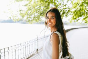 rear view shot of happy young brunette woman smiling broadly wit