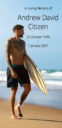 Tattooed man with surfboard on beach.